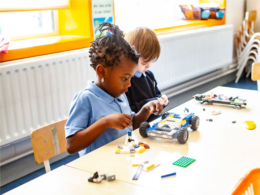 Girl building car with Lego