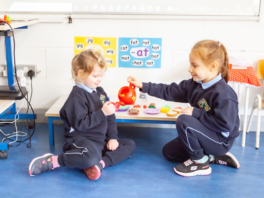 Children playing with tea set in classroom